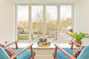 a living room with two chairs and a large window at The Apple Loft in Ambleside