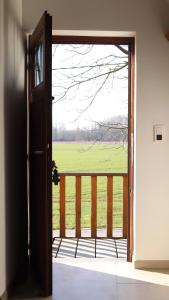 una porta aperta con vista su un campo di De Heide, cozy apartment with separate entrance a Kampenhout
