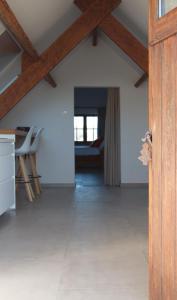 a kitchen and living room with a wooden ceiling at De Heide, cozy apartment with separate entrance in Kampenhout