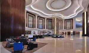 un vestíbulo con una gran lámpara de araña en un edificio en Dongguan Kande International Hotel, en Dongguan