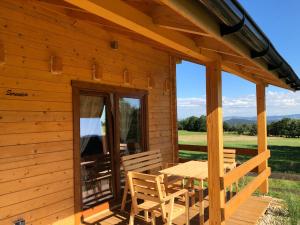 a wooden cabin with a table and chairs on the porch at Osada Karkonoska in Kowary