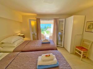 a bedroom with two beds with towels on them at Paleopetres K-Five - Premium Double Suite - Kalami - in Kalami