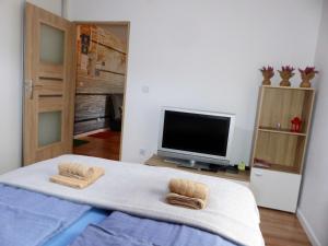 a bedroom with a bed with two towels on it at Apartament Kraszewskiego in Bytom