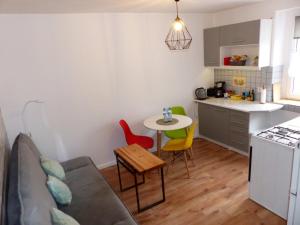 uma sala de estar com um sofá, uma mesa e uma cozinha em Apartament Kraszewskiego em Bytom