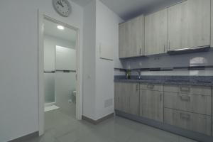 a kitchen with wooden cabinets and a clock on the wall at Puerto Mogan Apartment in Puerto de Mogán +14 photos