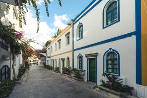 an alley in a town with white and blue buildings at Puerto Mogan Apartment in Puerto de Mogán