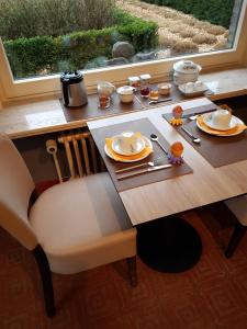 een eettafel met een houten tafel en een raam bij B & B DE SERAFIJN in Lochristi