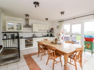 a kitchen with a wooden table and chairs at Caecrwn in Brecon