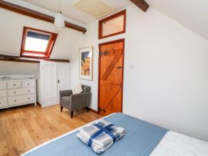 1 dormitorio con 1 cama y 1 silla en Caecrwn, en Brecon