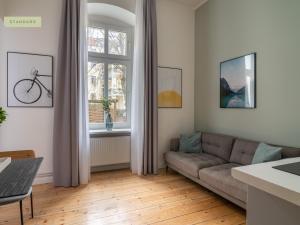 ein Wohnzimmer mit einem Sofa und einem Fenster in der Unterkunft Apartments Berlin Bornimer Straße in Berlin