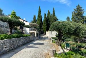 a house with a stone wall and a driveway at Paleopetres K-Five - Premium Double Suite - Kalami - in Kalami