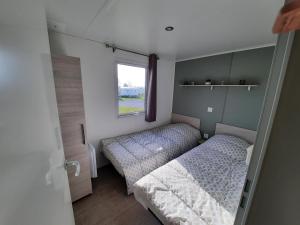 Habitación pequeña con 2 camas y ventana en Savina, en Litteau