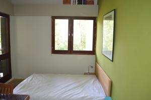 1 dormitorio con cama y ventana en Appartement Duplex RS Tursan Pour 5 Personnes Proche De La Plage Des Bourdaines en Seignosse