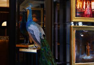 a peacock statue on display in a window at The Mayfair Townhouse - an Iconic Luxury Hotel in London