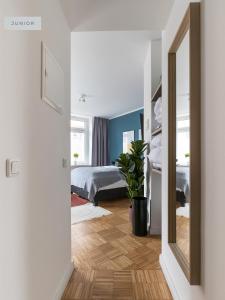 ベルリンにあるApartments Berlin Aroser Alleeの鏡付きの部屋、ベッド付きのベッドルーム1室が備わります。