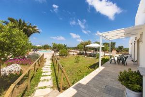 a patio with a table and chairs and a pool at Villa Martina by BarbarHouse in Carovigno