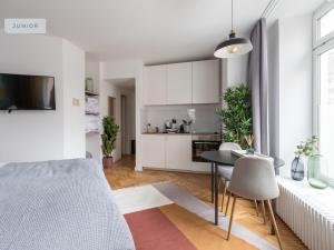 柏林的住宿－Apartments Berlin Aroser Allee，厨房以及带床和桌子的客厅。