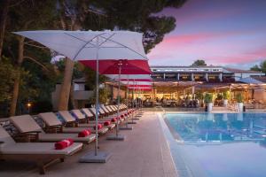 - une piscine avec des chaises longues et un parasol à côté de la piscine dans l'établissement Village Galijot Plava Laguna, à Poreč