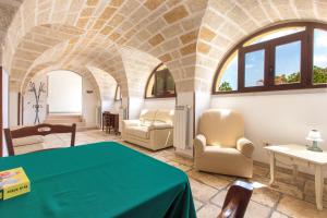 a living room with a green table and chairs at Villa Martina by BarbarHouse in Carovigno