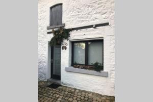 ein weißes Backsteinhaus mit einem Fenster darauf in der Unterkunft La Maison de Mamy in Spa