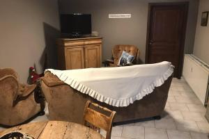 eine Badewanne in einem Zimmer mit Stühlen und einem Fernseher in der Unterkunft La Maison de Mamy in Spa