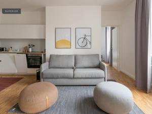 a living room with a couch and two ottomans at Apartments Berlin Aroser Allee in Berlin