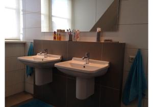 a bathroom with two sinks and a mirror at Vakantiewoning Yerseke in Yerseke +21 photos