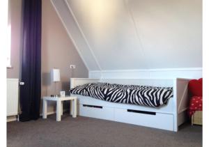 a zebra print bed in a bedroom with a white at Vakantiewoning Yerseke in Yerseke