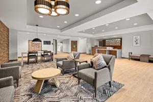 an office lobby with chairs and a table and a desk at Candlewood Suites Sumner Puyallup Area, an IHG Hotel in Sumner