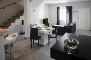 a living room with a table and a dining room at Maison tendance avec jardin, centre village, Alpilles, familles in Eyragues