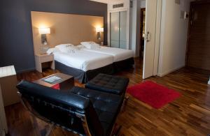 a hotel room with two beds and a couch at Eurostars Marqués de Vallejo in Logroño