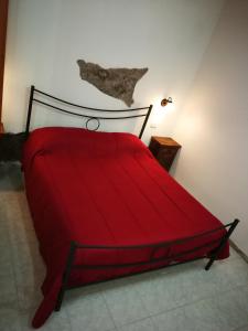 uma cama vermelha num quarto com um edredão vermelho em Casa del vico em Catânia