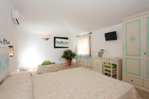 sypialnia z 2 łóżkami, biurkiem i telewizorem w obiekcie Residenza di Campagna Seranile w mieście Dorgali