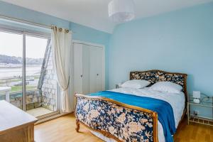een slaapkamer met een bed en een groot raam bij Ker Paul et Ker Julien- appartements vue mer in Erquy