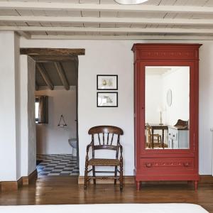 a red chair in a room with a mirror at La Cour du Marronnier in Pont-de-Barret