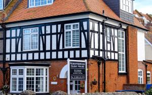 a black and white building with a sign in front of it at Robertsbrook Guest House in Swanage