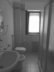 a bathroom with a toilet and a sink and a window at Casa Nica in Modica