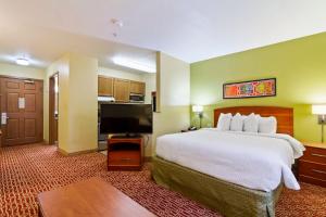 a hotel room with a large bed and a flat screen tv at Extended Stay America Suites - Virginia Beach in Virginia Beach