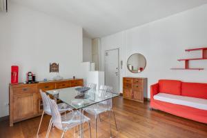 a living room with a table and chairs and a couch at Easylife - Strategic apt in Washington in Milan