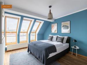 Schlafzimmer mit blauen Wänden, einem Bett und Fenstern in der Unterkunft Apartment Berlin Am Friedrichshain in Berlin