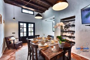 a dining room with a wooden table and chairs at Vivienda Vacacional El Patio de Franky in Teguise