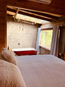 1 dormitorio con cama y bañera en Cabana Monte - Pousada Colina dos Ventos, en Urubici
