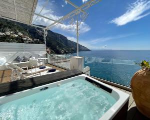 a hot tub on a balcony with a view of the ocean at Hotel Montemare in Positano