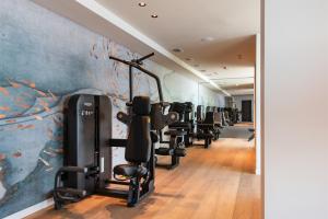 einen Fitnessraum mit einer Reihe von Heimtrainern und einem Wandbild in der Unterkunft EALA My Lakeside Dream - Adults Friendly in Limone sul Garda