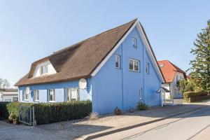 a blue house with a brown roof on a street at Mohnblume in Zirkow