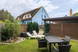 a backyard with a table and chairs and a house at Ferienwohnung Kornblume in Zirkow