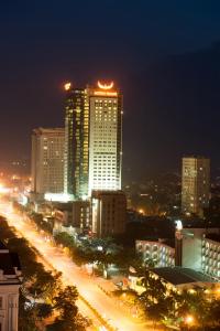 a city skyline at night with a tall building at Muong Thanh Luxury Song Lam Hotel in Vinh