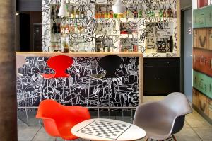 a room with chairs and a wall covered in graffiti at ibis Clermont Ferrand Nord Riom in Riom