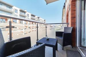 a balcony with chairs and a view of a city at Modern Apartments Wrocław Kościuszki by Renters in Wrocław