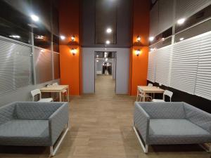 a waiting room with couches and tables and orange walls at ОТЕЛЬ СОН lite in Yekaterinburg